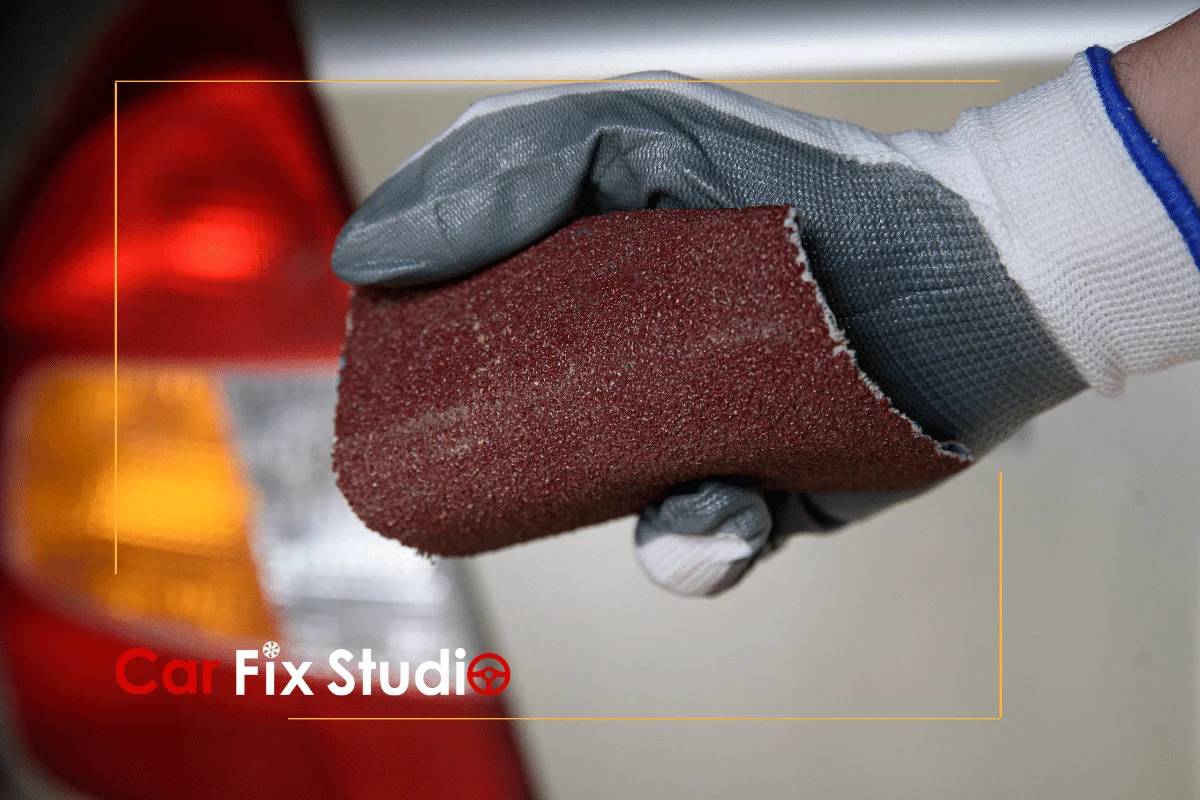 using a sandpaper to remove the damage by acetone on car paint